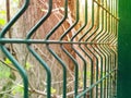 Steel grating fence made with wire in spring. Steel lattice fence soccer field, metal wire fence with trees Royalty Free Stock Photo