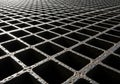 A steel grid with a repeating pattern of square openings, creating a textured surface. Royalty Free Stock Photo
