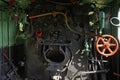 The steel heavy machinery with rusty red valves; counters and tubes inside steam locomotive engine in Mysore