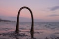 Steel hinges from reinforcement stick out of the water on the old pier. Dawn. Mainly cloudy. Coast Royalty Free Stock Photo