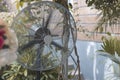 A steel industrial fan at an outdoor al fresco garden event venue