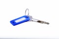 Steel key with blue key fob on a white background Royalty Free Stock Photo