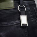 Steel key ring hanging on black jeans. Blank key chain for your design. Souvenir or accessory. Can put text, image, and logo Royalty Free Stock Photo