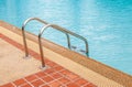 Steel ladder in blue swimming pool