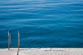 Steel ladder on pier with turquoise adriatic ocean in Triest