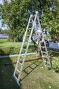 Steel ladder standing under apple tree for ripe apples harvesting, home garden