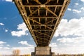 Steel lattice construction of a railway bridge on a background of blue sky with white clouds. Royalty Free Stock Photo