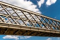 Steel lattice construction of a railway bridge on a background of blue sky with white clouds. Royalty Free Stock Photo