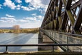 Steel, lattice structure of a railway bridge over a river with a background of blue sky with white clouds in western Germany. Royalty Free Stock Photo