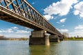 Steel, lattice structure of a railway bridge over a river with a background of blue sky with white clouds in western Germany. Royalty Free Stock Photo