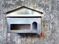 Steel mailbox house shape on old cement wall