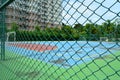 Steel mesh fence with soccer field background Royalty Free Stock Photo