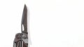A steel multi-tool with an open knife blade lies on a white background. Pocket open folding knife. Portable multitasking