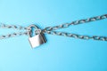 Steel padlock and chains on light blue background. Safety concept Royalty Free Stock Photo