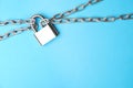 Steel padlock, chains and space for text on blue background, top view. Safety concept Royalty Free Stock Photo