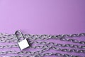 Steel padlock, chains and space for text on purple background, flat lay. Safety concept Royalty Free Stock Photo