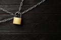 Steel padlock, chains and space for text on wooden background, flat lay. Safety concept Royalty Free Stock Photo