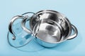 Steel pan with a transparent lid on blue background Royalty Free Stock Photo