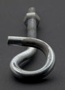 Steel pigtail screw hook on black background.