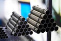 Steel pipes against industrial blurred background, close-up