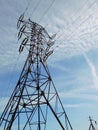 Electric pole of transmission line against a blue sky and white clouds Royalty Free Stock Photo