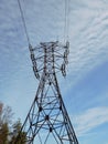 Electric pole of transmission line against a blue sky and white clouds Royalty Free Stock Photo