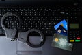 Steel police handcuffs, bank cards and payment device lying on k Royalty Free Stock Photo