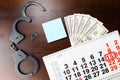 Steel police handcuffs, dollars money and April 15 on calendar,