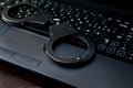 Steel police handcuffs lying on keyboard. Concept of internet cr Royalty Free Stock Photo