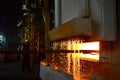Steel quenching at high temperature in industrial furnace at the workshop of a forge plant.