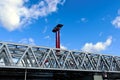 steel railway bridge closeup in perspective view. red steel tower with solar panels. blue sky