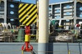 Steel red hook and black and yellow hoist block of ship\'s cargo crane secured by rope on main deck of container vessel. Royalty Free Stock Photo