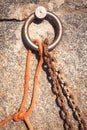 Steel ring and mooring lines in a seaport. Rusty iron chain and hemp rope Royalty Free Stock Photo