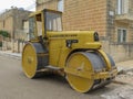 Steel road roller parked in a street with road works