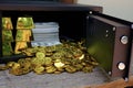 Steel safes box full of coins stack and gold bar