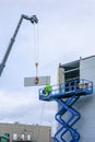 Sandwich panels wall mounting using crane and scissor lift