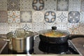 a steel saucepan and a frying pan with stewed vegetables on a electric stove