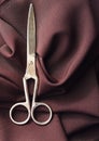 The steel scissors on Burgundy fabric