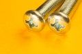Steel screw on a yellow background