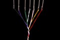 7 steel sewing needles threaded with various colored threads which are twisted into a simble thick thread. Room for copy left and