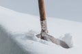 A steel shovel for snow removal with wooden handle