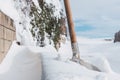 a steel shovel with wooden handle in snow on nature