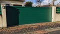 Steel sliding large green metal gate fence on modern house street Royalty Free Stock Photo