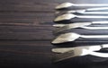 Steel spoons and forks in a row on a table. Royalty Free Stock Photo