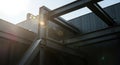 Steel structural beams form a complex framework against a bright sky generated