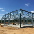 Steel structure under construction at a worksite with a clear blue sky background Royalty Free Stock Photo