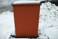 Steel tank. Dumpster. Place to store sand on highway. Orange object in winter on road
