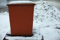 Steel tank. Dumpster. Place to store sand on highway. Orange object in winter on road