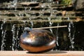 Steel tongue drum with mallet near waterfall outdoors on sunny day. Percussion musical instrument