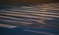 Steel tram tracks and white cross walk on asphalt road illuminated by street lights, closeup night photo Royalty Free Stock Photo